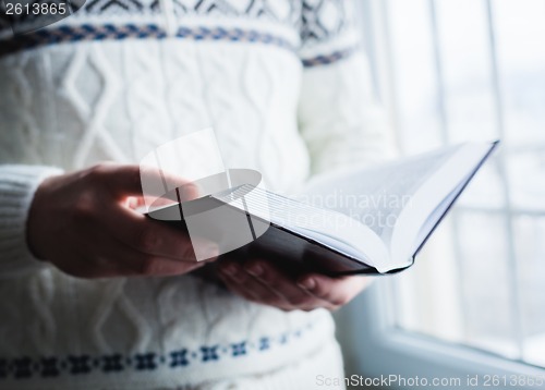 Image of Man reading. Book in his hands.
