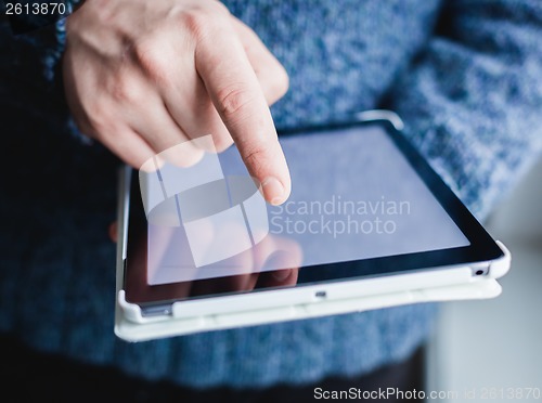 Image of The man uses a tablet PC. Modern gadget in hand.