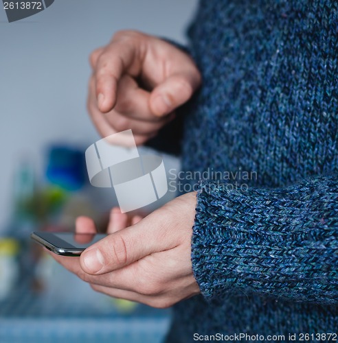 Image of The man is using a smartphone. Modern mobile phone in hand.