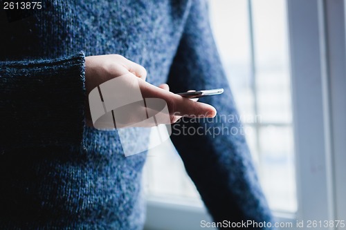 Image of The man is using a smartphone. Modern mobile phone in hand.