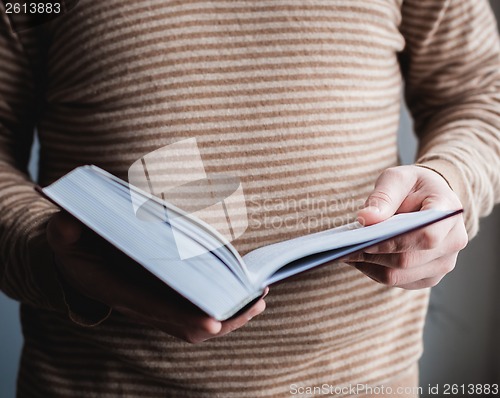 Image of Man reading. Book in his hands.