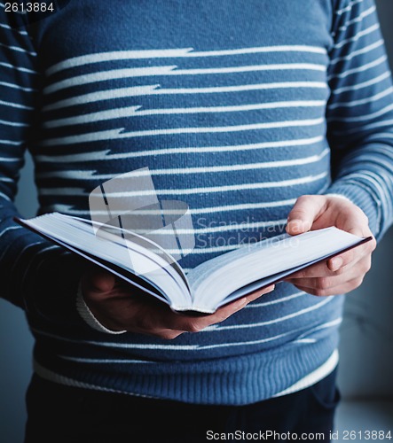 Image of Man reading. Book in his hands.