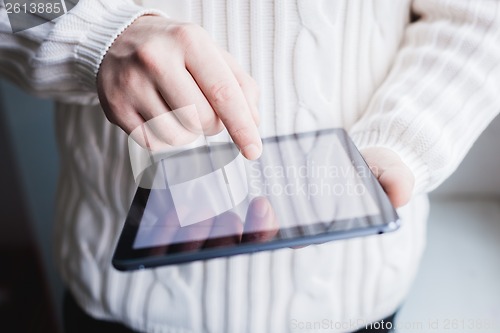 Image of The man uses a tablet PC. Modern gadget in hand.