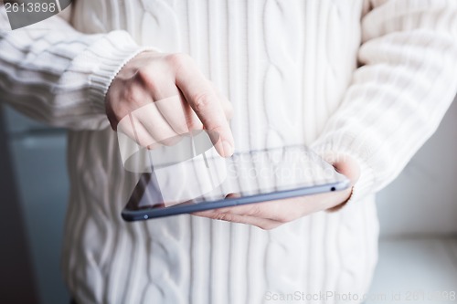 Image of The man uses a tablet PC. Modern gadget in hand.