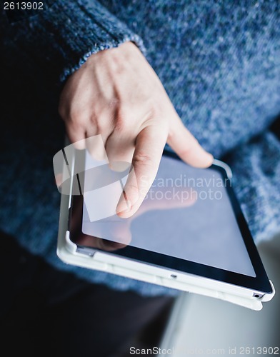 Image of The man uses a tablet PC. Modern gadget in hand.
