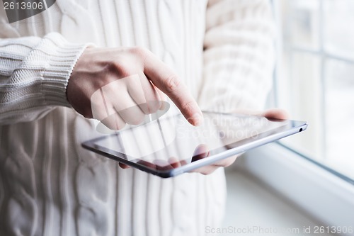 Image of The man uses a tablet PC. Modern gadget in hand.