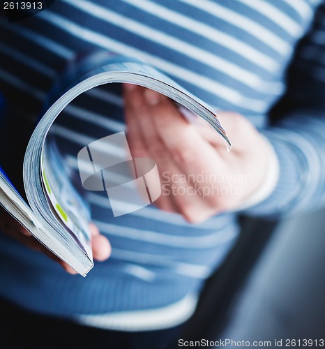 Image of A man looks at a magazine. Press hands.