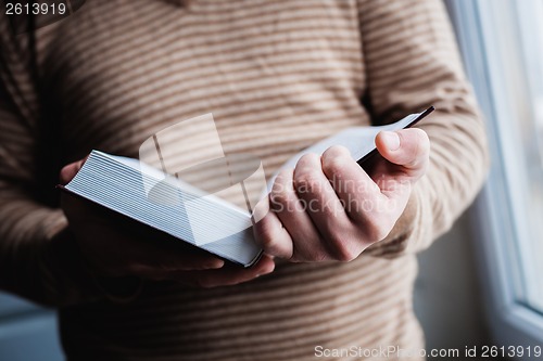 Image of Man reading. Book in his hands.