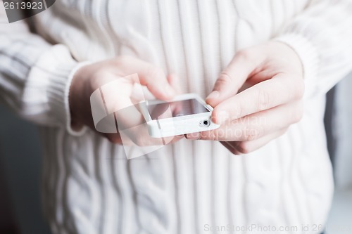 Image of The man is using a smartphone. Modern mobile phone in hand.