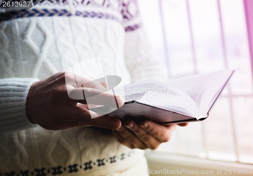 Image of Man reading. Book in his hands.