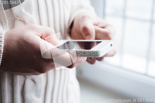 Image of The man is using a smartphone. Modern mobile phone in hand.