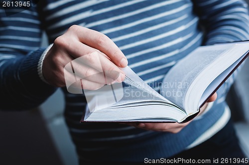 Image of Man reading. Book in his hands.