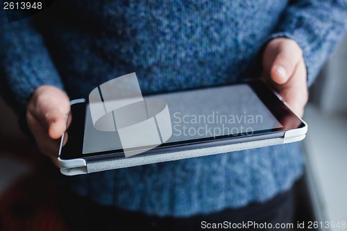 Image of The man uses a tablet PC. Modern gadget in hand.