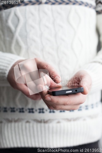 Image of The man is using a smartphone. Modern mobile phone in hand.