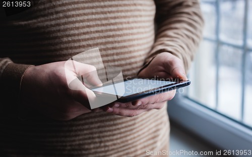 Image of The man uses a tablet PC. Modern gadget in hand.