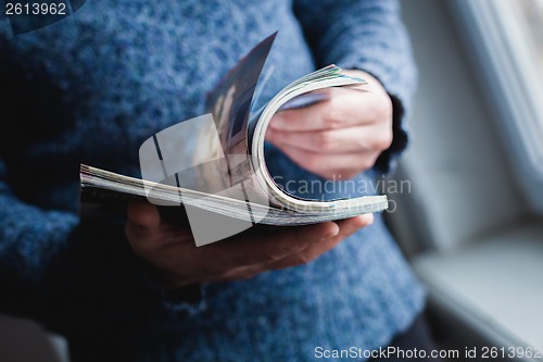 Image of A man looks at a magazine. Press hands.