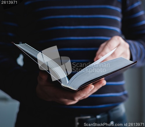 Image of Man reading. Book in his hands.