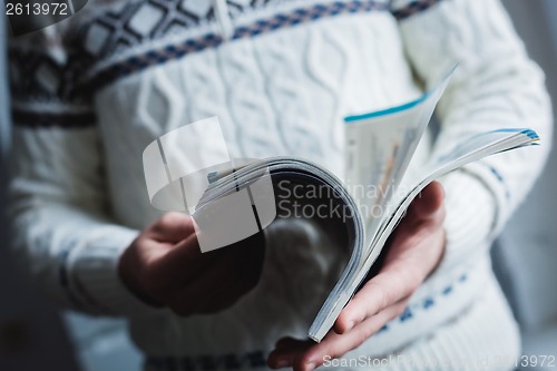 Image of A man looks at a magazine. Press hands.