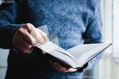 Image of Man reading. Book in his hands.