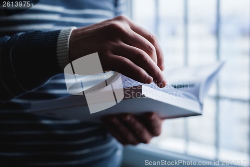 Image of Man reading. Book in his hands.