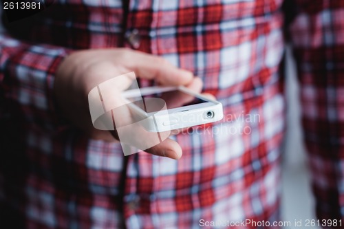 Image of The man is using a smartphone. Modern mobile phone in hand.