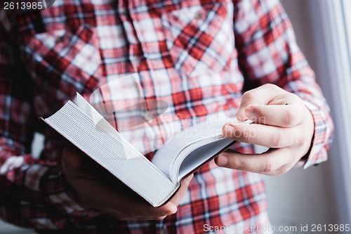 Image of Man reading. Book in his hands.