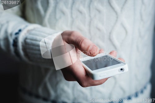 Image of The man is using a smartphone. Modern mobile phone in hand.