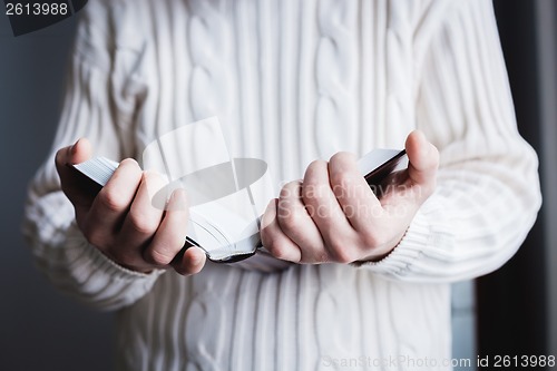 Image of Man reading. Book in his hands.