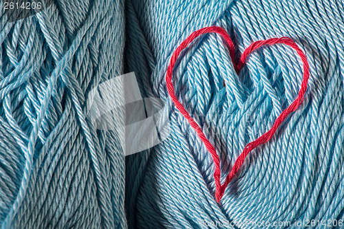 Image of Knitted red heart on blue