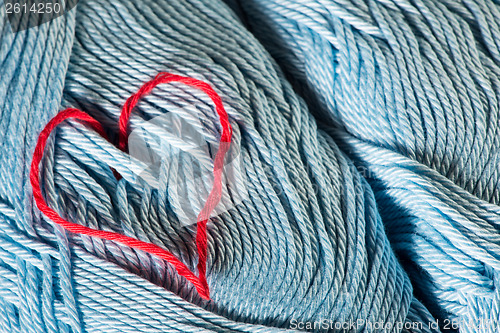 Image of Knitted red heart on blue