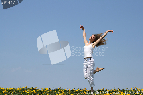 Image of Smiling girl dancing in dandelion field