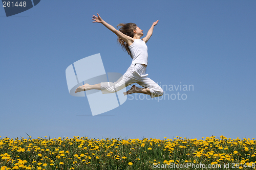 Image of Girl flying in a jump over dandelion field