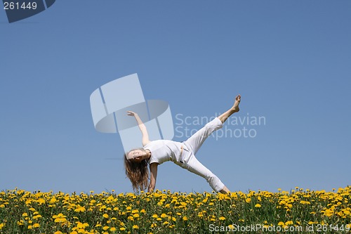 Image of Smiling young woman exercising in dandelion field