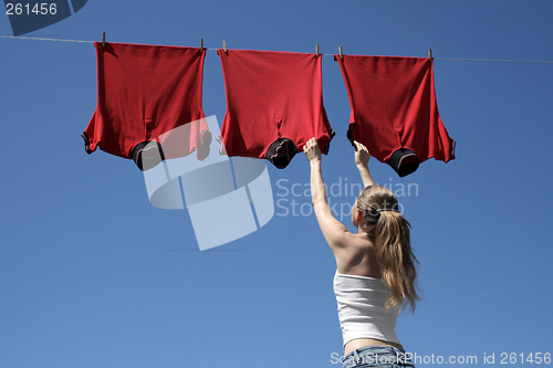 Image of Girl, blue sky and red laundry