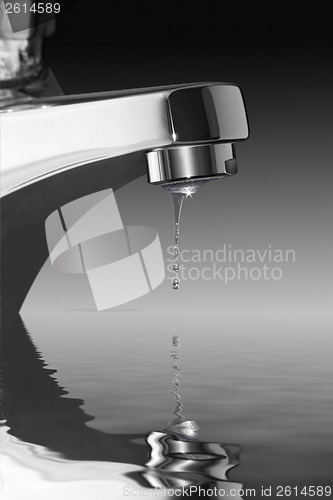 Image of dripping faucet over water surface