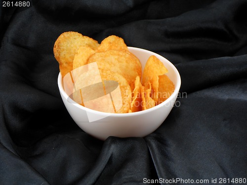 Image of Chips in a plate on black material background