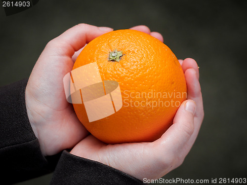 Image of Orange in the hands of a child 