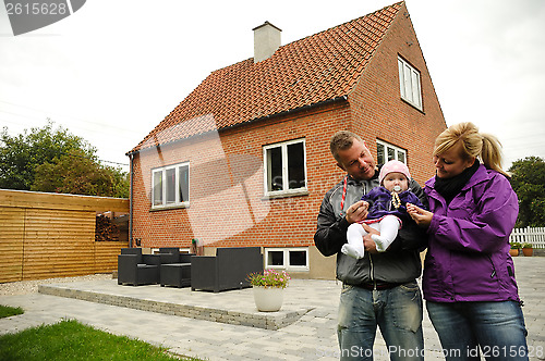 Image of Happy family in front of house
