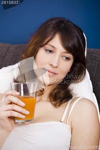 Image of Drinking orange juice on bed