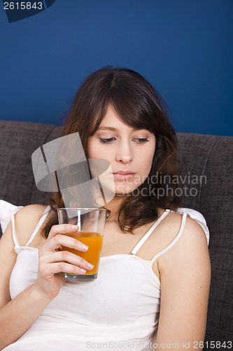 Image of Drinking orange juice on bed