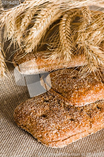 Image of Rye bread and wheat on cloth sack, close-up