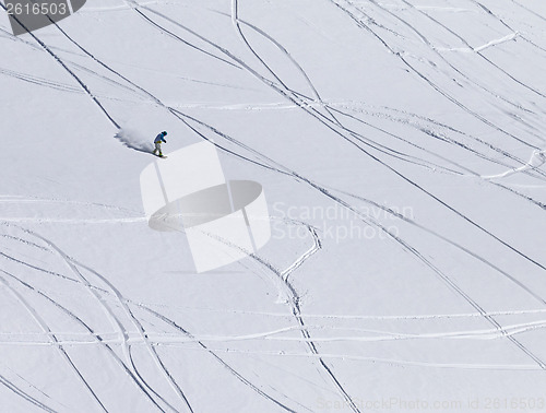 Image of Snowboarder downhill on off piste slope with newly-fallen snow