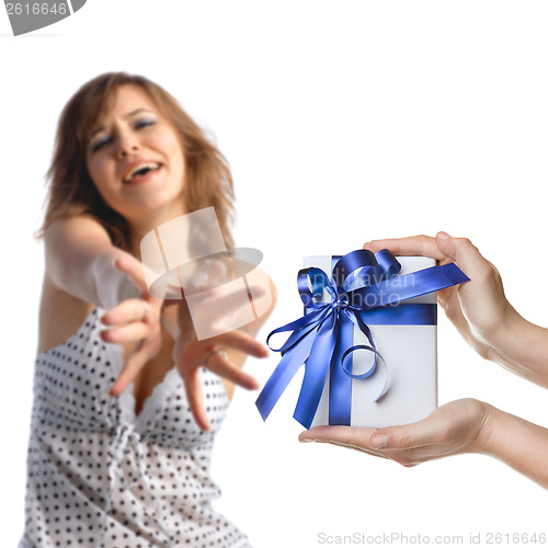 Image of A girl reaching out for men's hands holding a present on white b