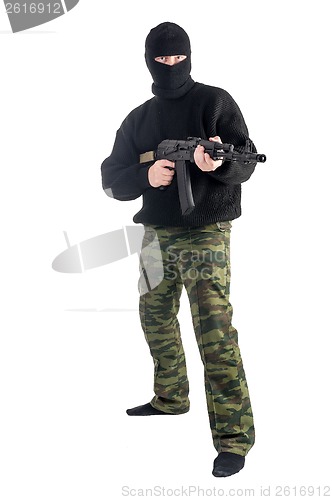 Image of masked man stands with rifle