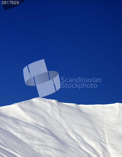 Image of Off-piste slope and blue clear sky in sun winter day