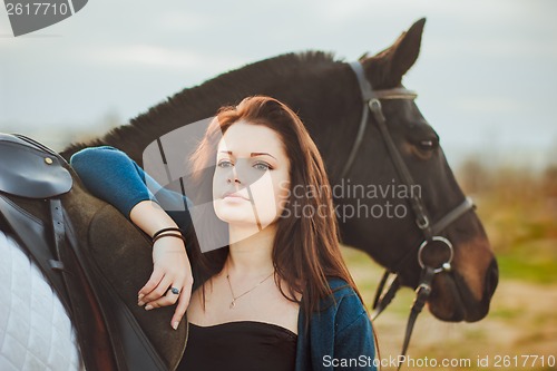 Image of Young woman with a horse on nature