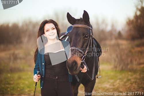 Image of Young woman with a horse on nature