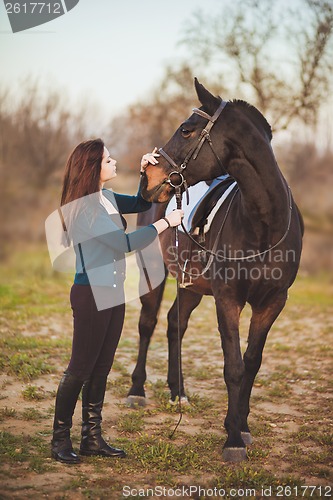 Image of Young woman with a horse on nature