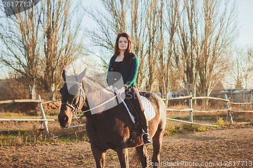 Image of Young woman with a horse on nature