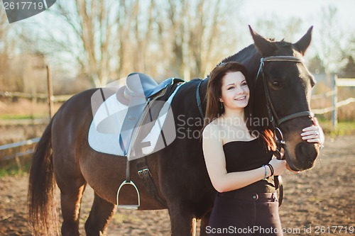 Image of Young woman with a horse on nature